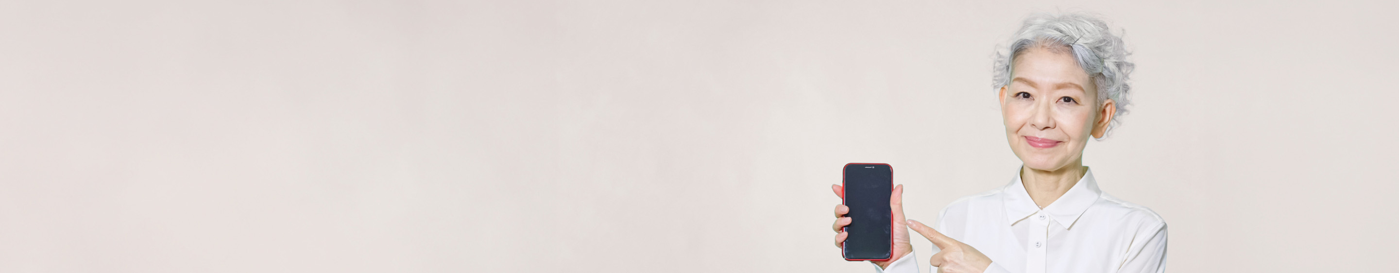 スマートフォンを指差す高齢者の女性